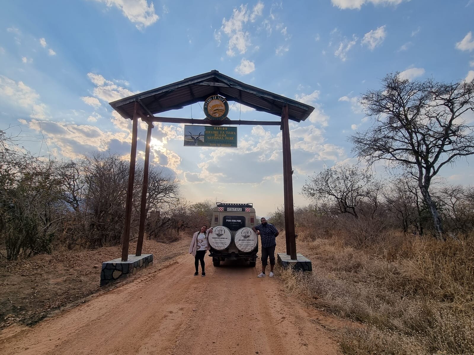 Two visitors standing at the Ruaha park entrance gate